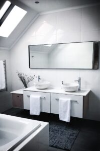 White modern bathroom with large mirror and 2 sinks