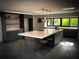 Modern kitchen cupboards with overhanging lights above kitchen counter