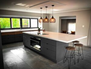 Modern kitchen cupboards with overhanging lights above kitchen counter