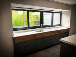 Modern kitchen cupboards with sink by window