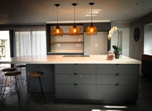 Modern kitchen cupboards with overhanging lights above kitchen counter