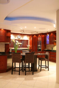 Custom kitchen with red cupboards and chairs around table