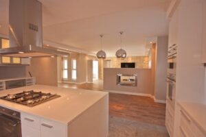 Modern kitchen cupboards with island unit and fireplace