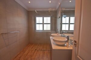 Clean bathroom with shower, sink and towel rack