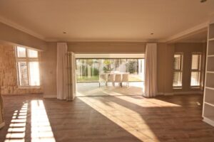 Clean and modern living room with large door leading to back yard