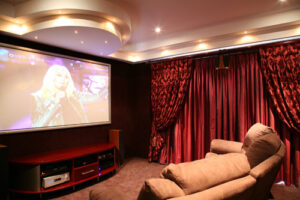 Home theater with red cupboards and curtains